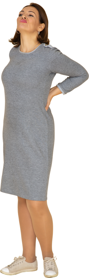 Vista frontal de uma mulher de vestido cinza fazendo caretas