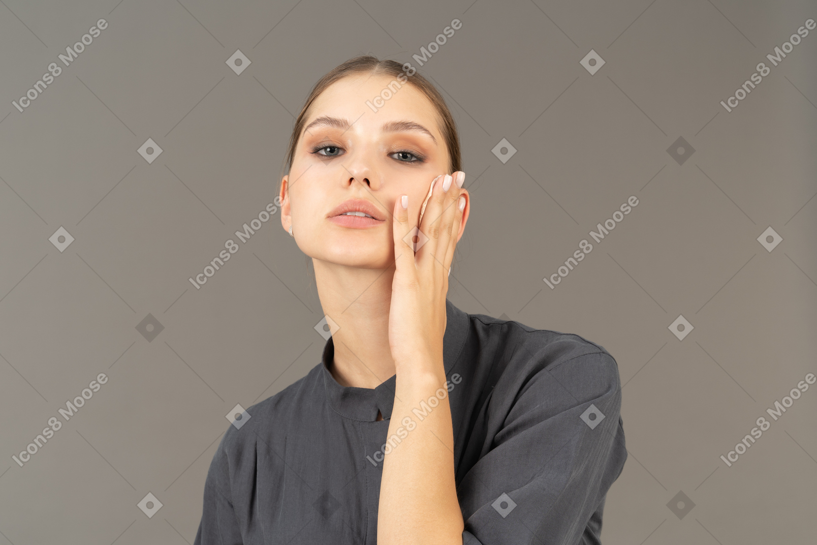 Молодая женщина в комбинезоне снимает макияж, вид спереди