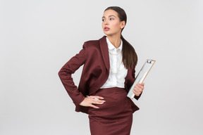 Attraente donna vestita formalmente in possesso di un blocco per appunti
