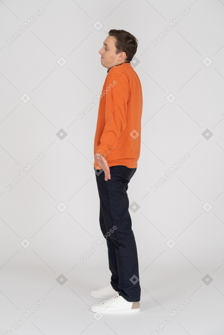 Young man in orange sweatshirt standing