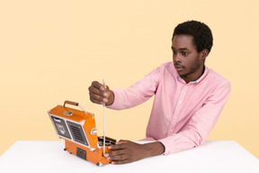 Handsome young man turning on a radio