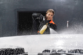 Young woman washing car