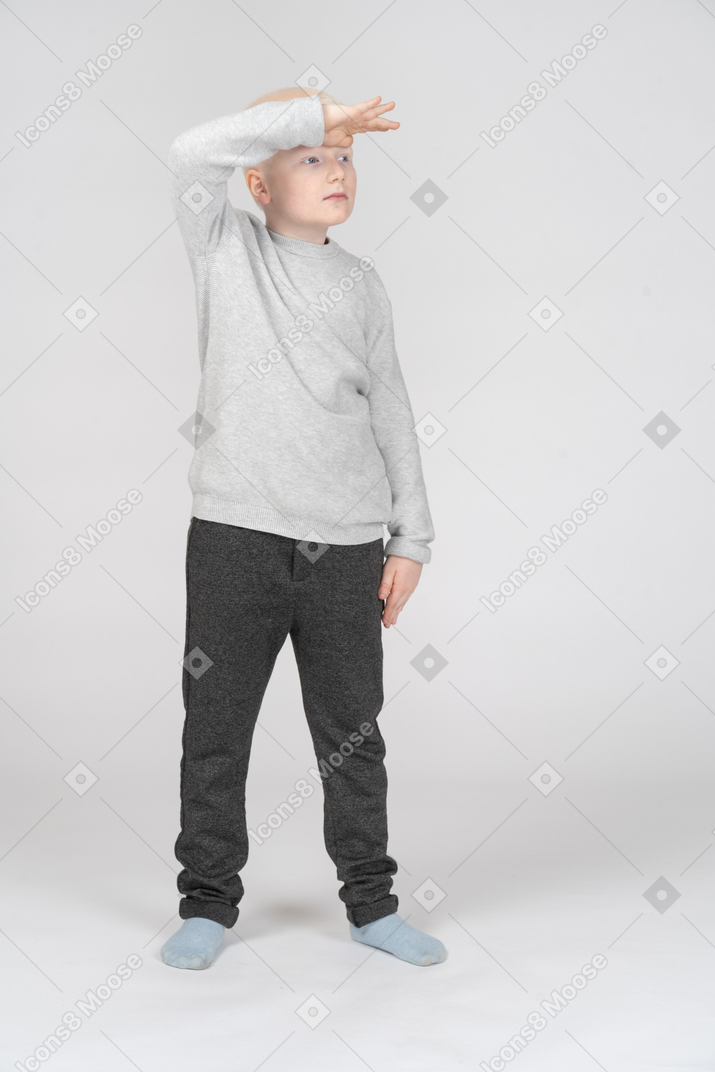 Front view of a little boy looking far away