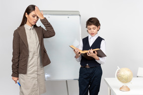 Dazed young teacher and a pupil answering in class