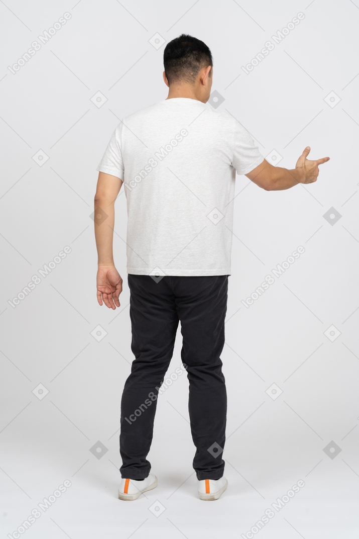 Vista traseira de um homem em roupas casuais, apontando algo com o dedo