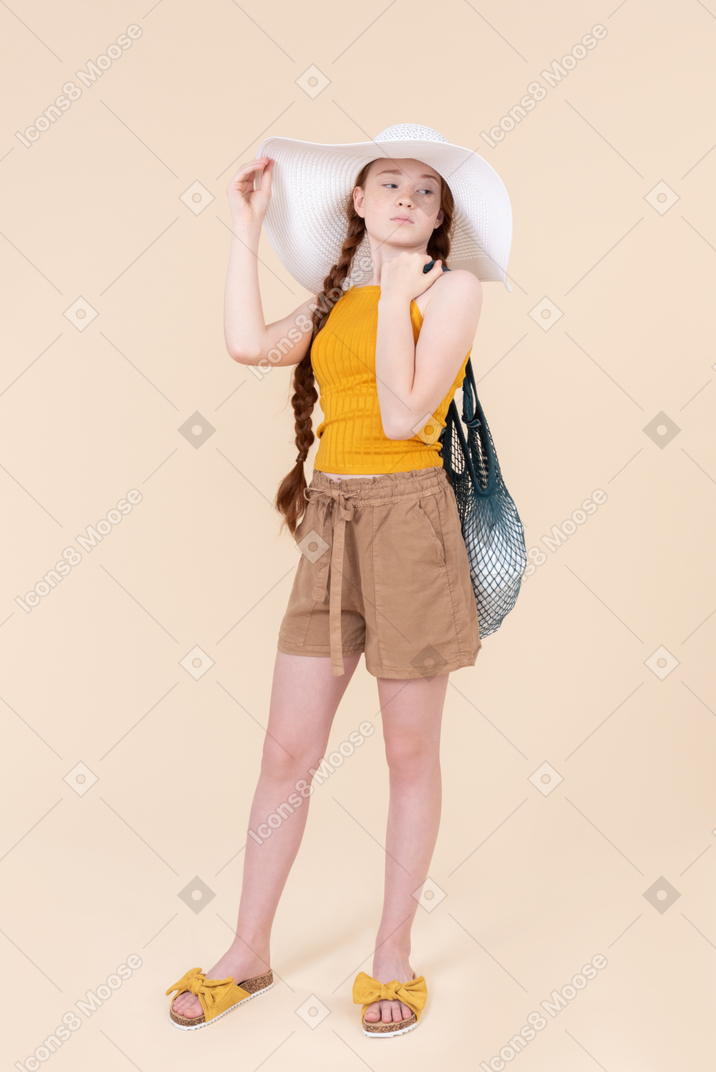 Teenage girl wearing white hat and holding avoska