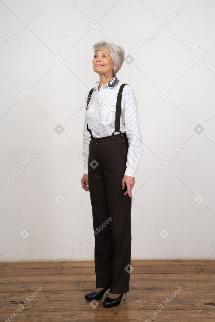 Three-quarter view of a displeased old woman in office clothes