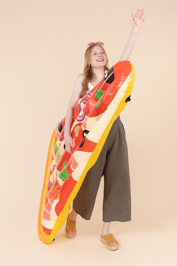 Smiling young woman holding pizza mattress
