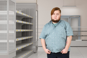 A man with a beard standing in front of shelves