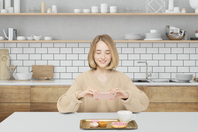 A woman taking photo of food in the kitchen