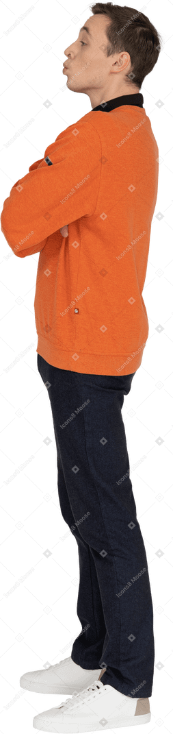 Junger mann im orangefarbenen sweatshirt stehend