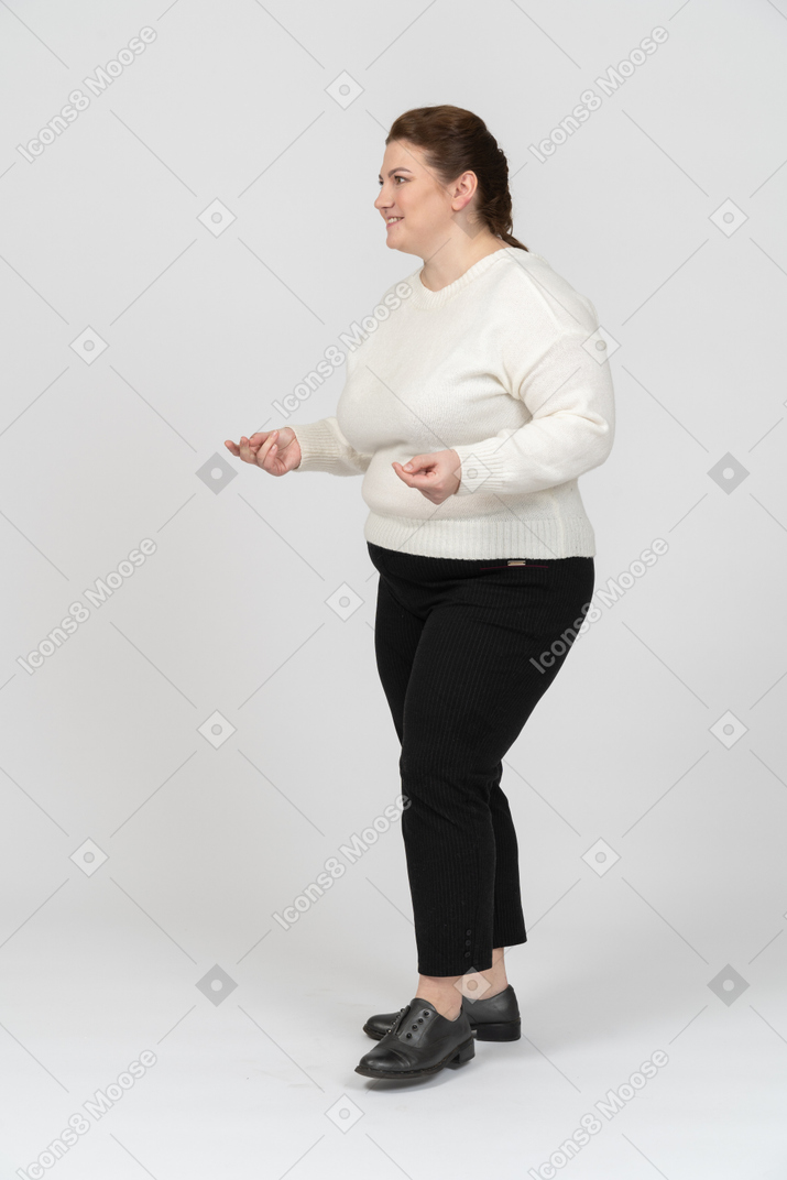 横顔に立っている白いセーターのふっくらした女性