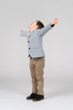 A young boy cheering with his arms in the air