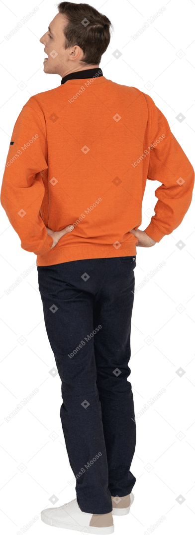 Junger mann im orangefarbenen sweatshirt stehend