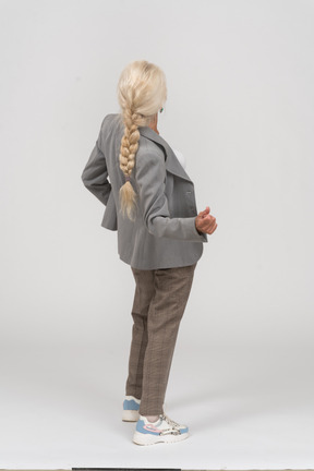 Back view of an old lady in suit bending back