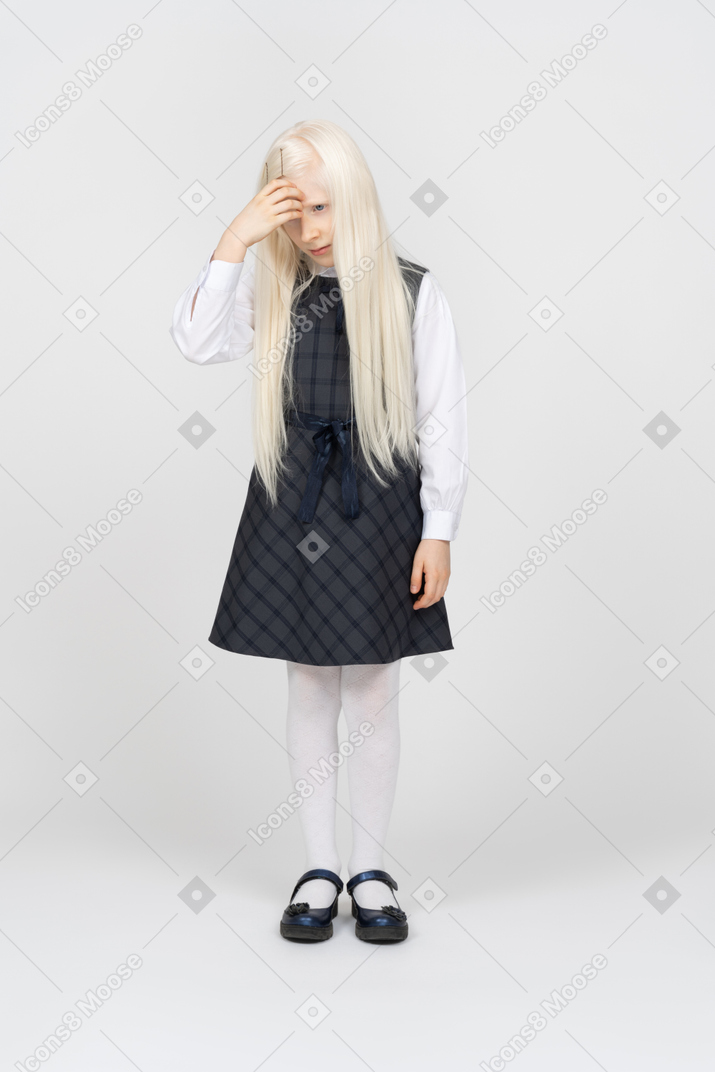 Schoolgirl looking upset and touching forehead
