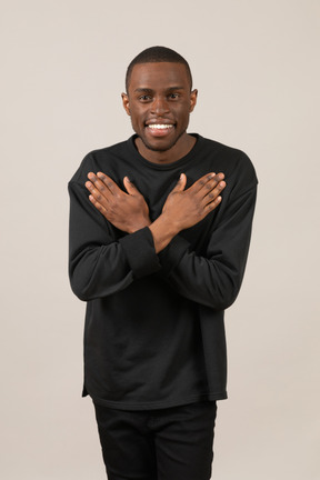 Positive young man with hands crossed on chest