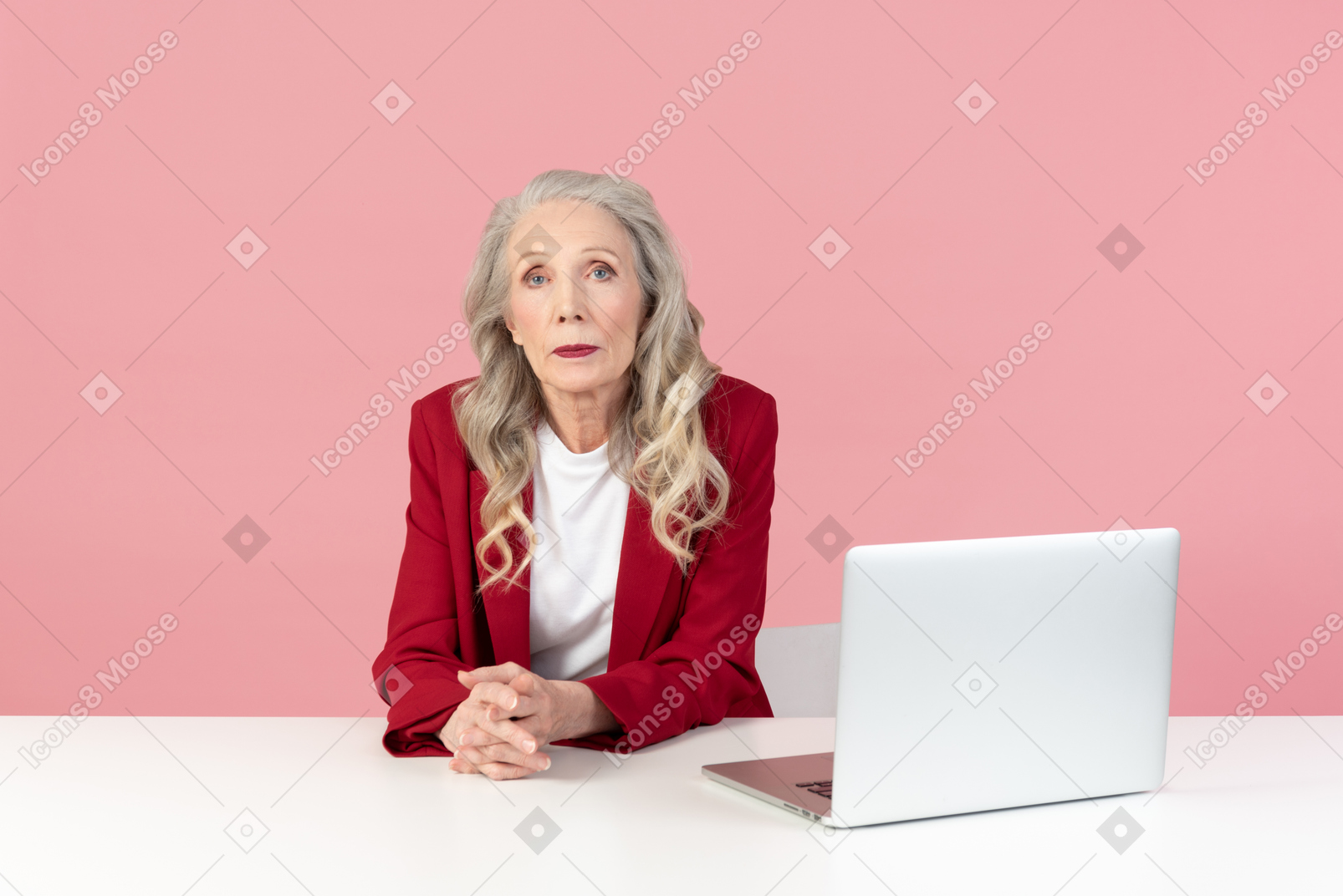 Пожилая стильная женщина сидит за офисным столом
