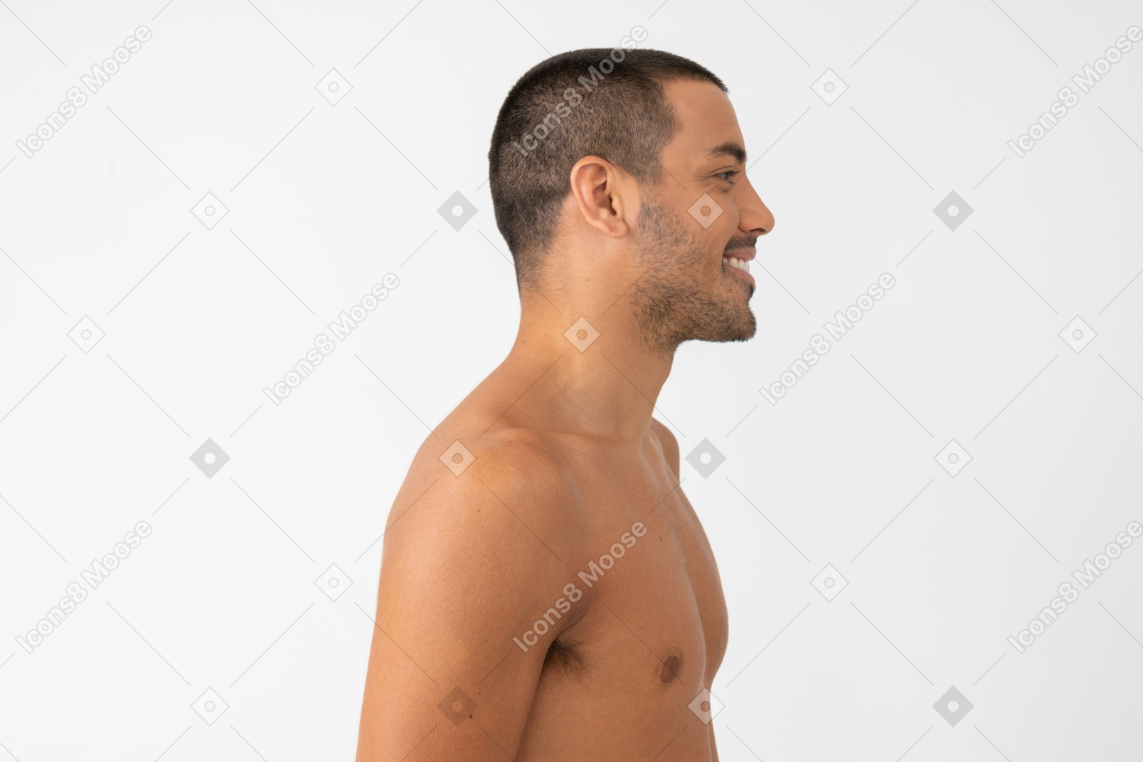 Barechested young man with a smile on his face standing in profile