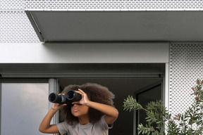 Cute little girl looking through binoculars