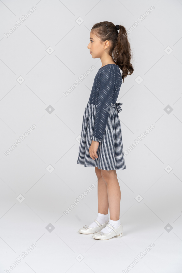 Vista lateral de uma garota de pé em linha reta