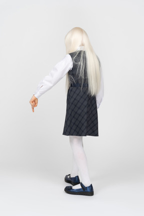 Back view of a schoolgirl pointing downwards