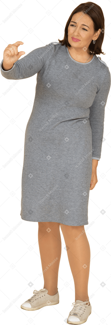 Vista frontale di una donna in abito grigio che mostra una piccola taglia di qualcosa