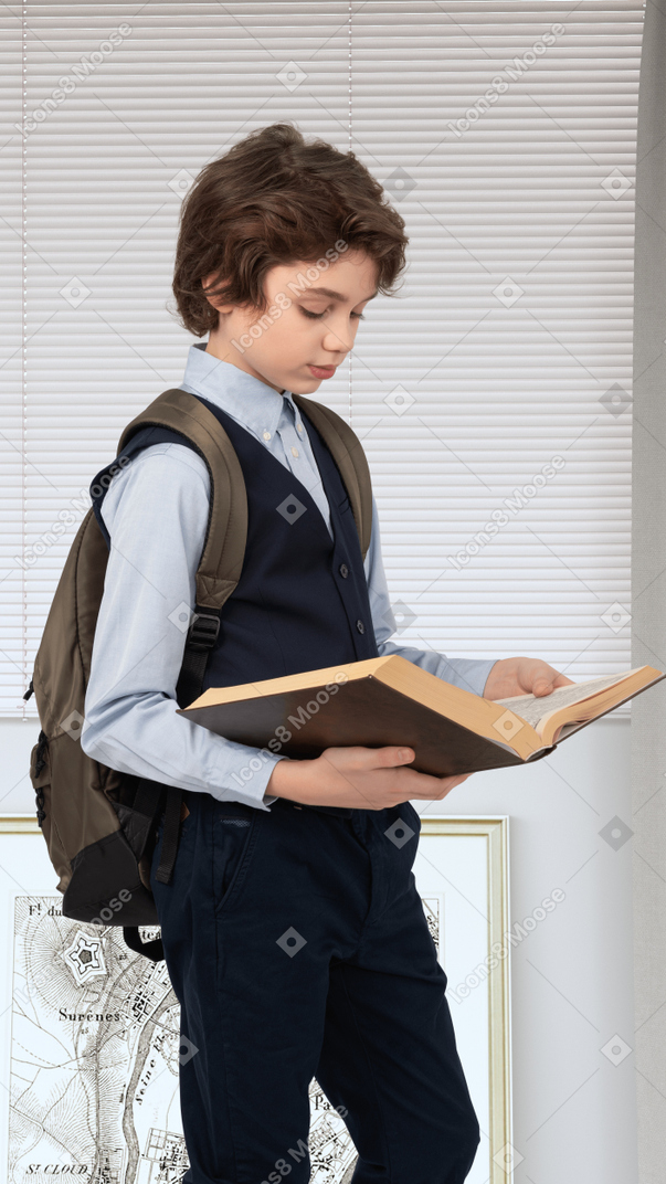 A young boy in a blue shirt holding a book