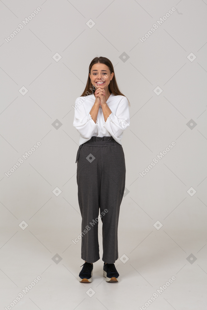 Vista frontale di una giovane donna contenta in abiti da ufficio che si tiene per mano insieme