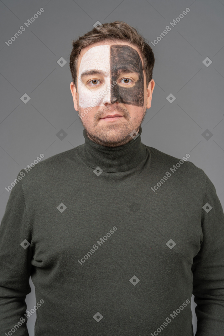 Front view of a male football fan with a black & white face art