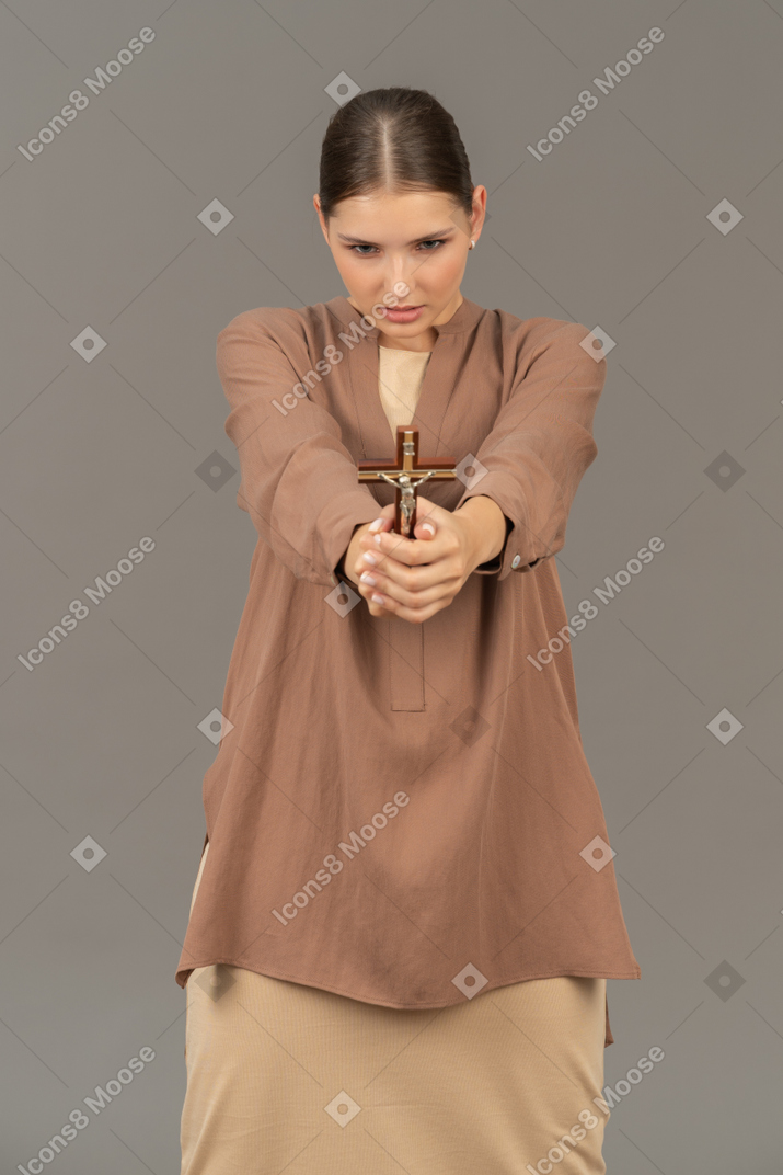 Christian lady holds a cross with both hands
