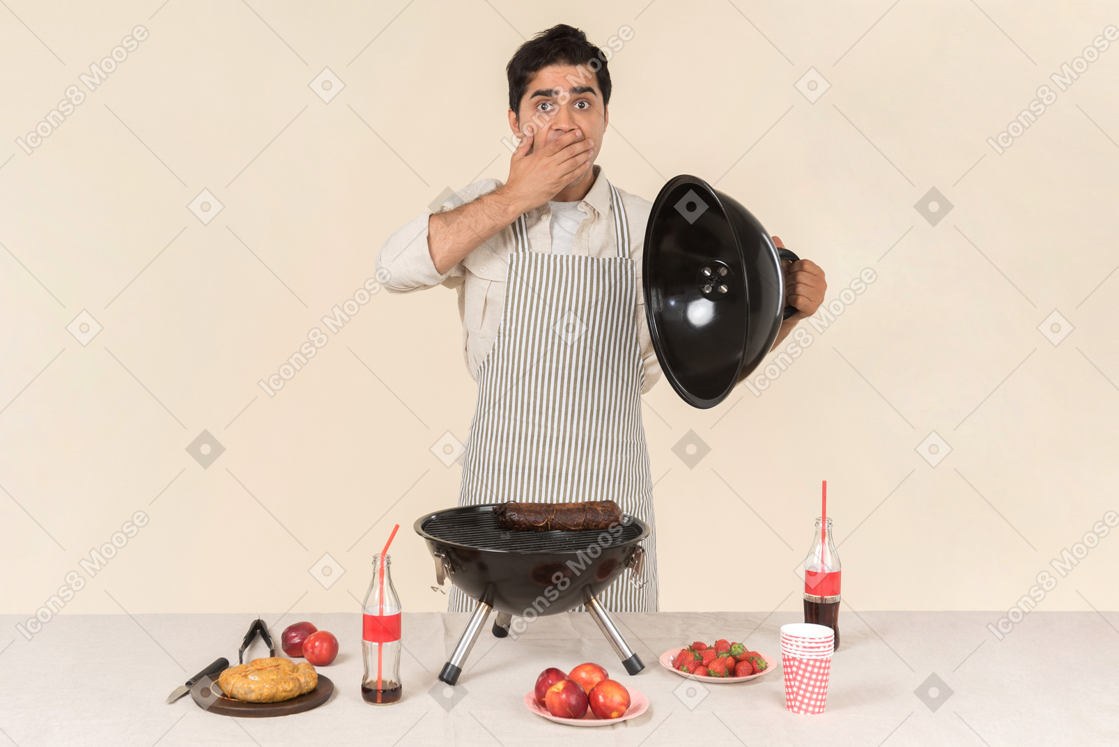 Задыхаясь молодой кавказский человек готовит барбекю