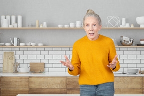 Shocked elderly woman in the kitchen