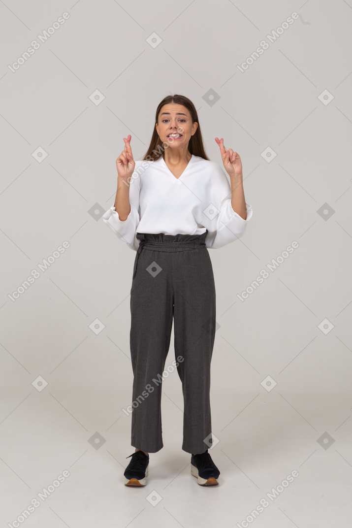 Front view of a young lady in office clothing crossing fingers