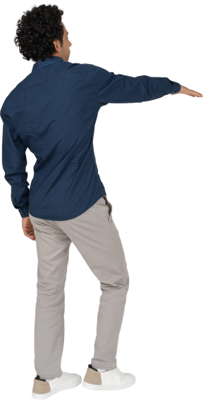Side view of a man in casual clothes pointing with hand