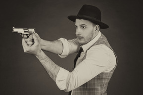 Elegant man in hat aiming the gun
