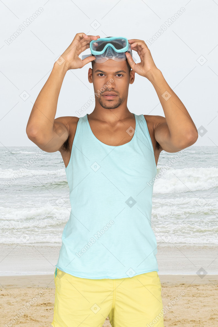 Young man taking off diving mask