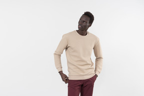 A young black man in a grey sweater standing alone on the white background