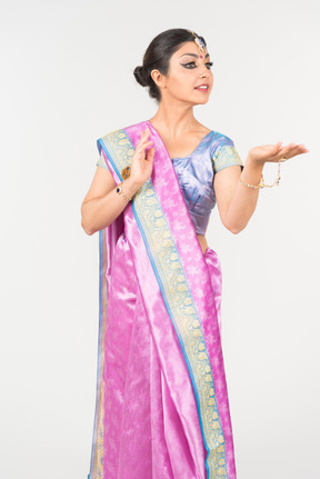 Young indian woman in purple sari dancing