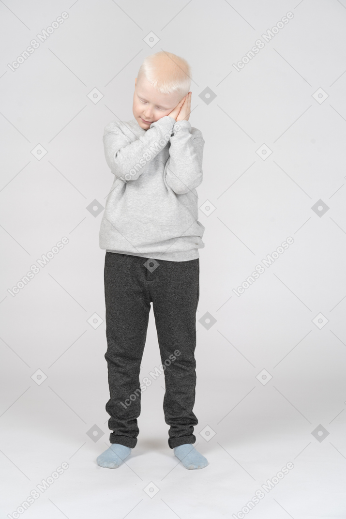 Front view of a boy imitating sleeping