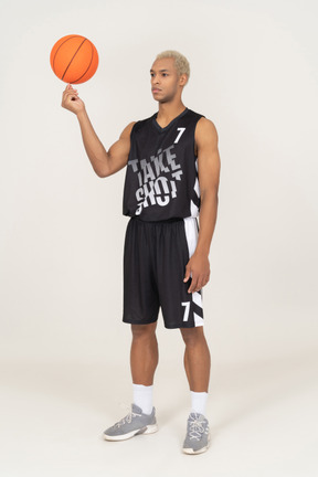 一名年轻男篮球运动员拿着球的四分之三视图