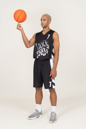 Three-quarter view of a young male basketball player holding a ball