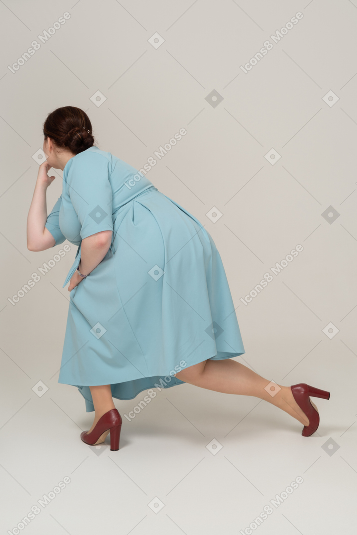 一个穿着蓝色裙子的女人蹲着的侧视图