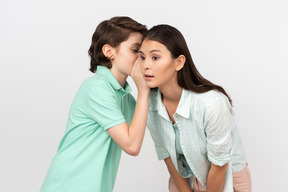 Chico atractivo compartiendo un secreto con su madre.