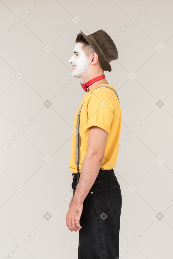 Smiling male clown standing in profile