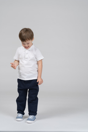 Front view of cheerful boy looking down