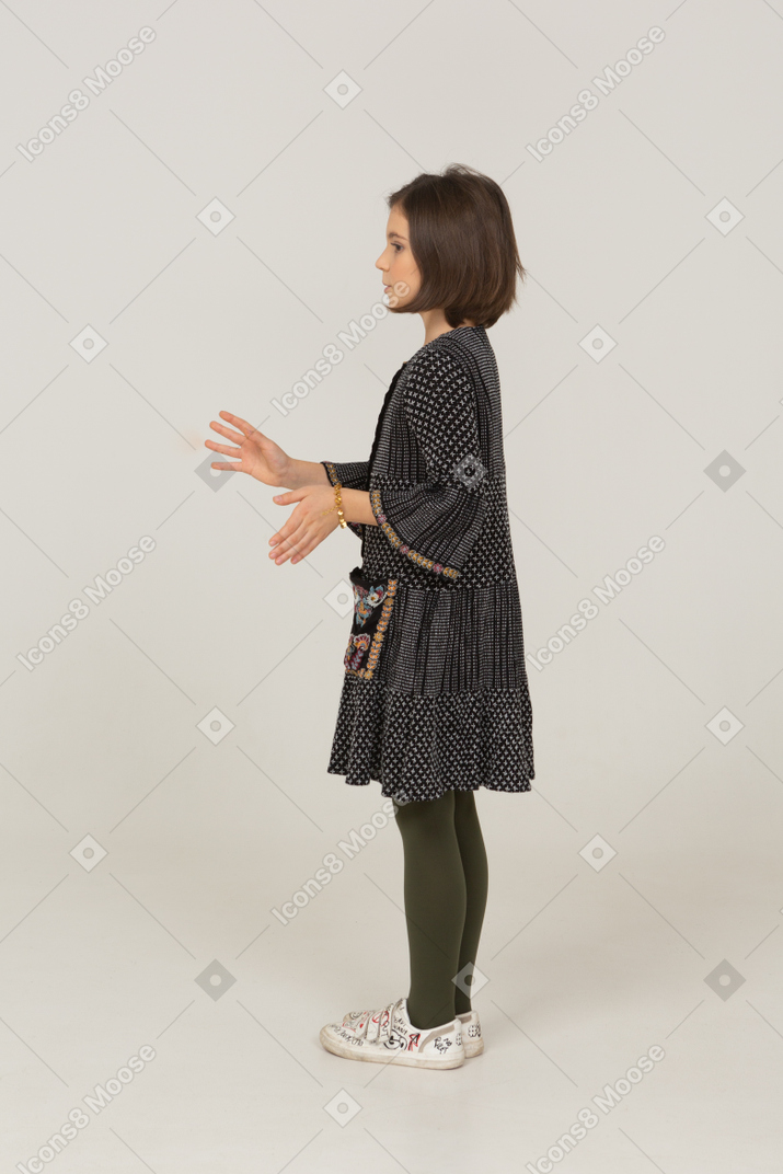 Side view of a gesticulating little girl in dress