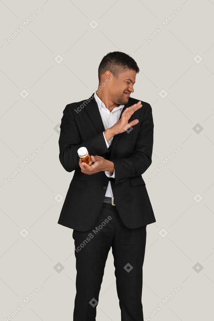 Disgusted african american man holding pills bottle