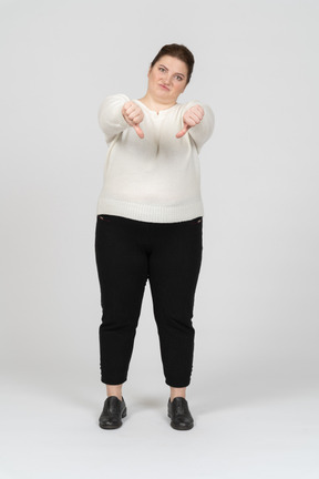 Unhappy plump woman showing thumbs down