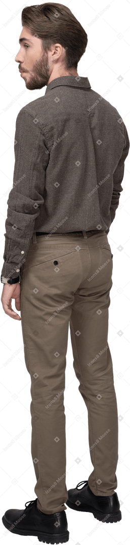 Vista posteriore di tre quarti di un giovane uomo in abiti da ufficio che rimbocca le guance